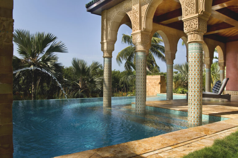 Moorish-inspired canal-front infinity pool with covered porch